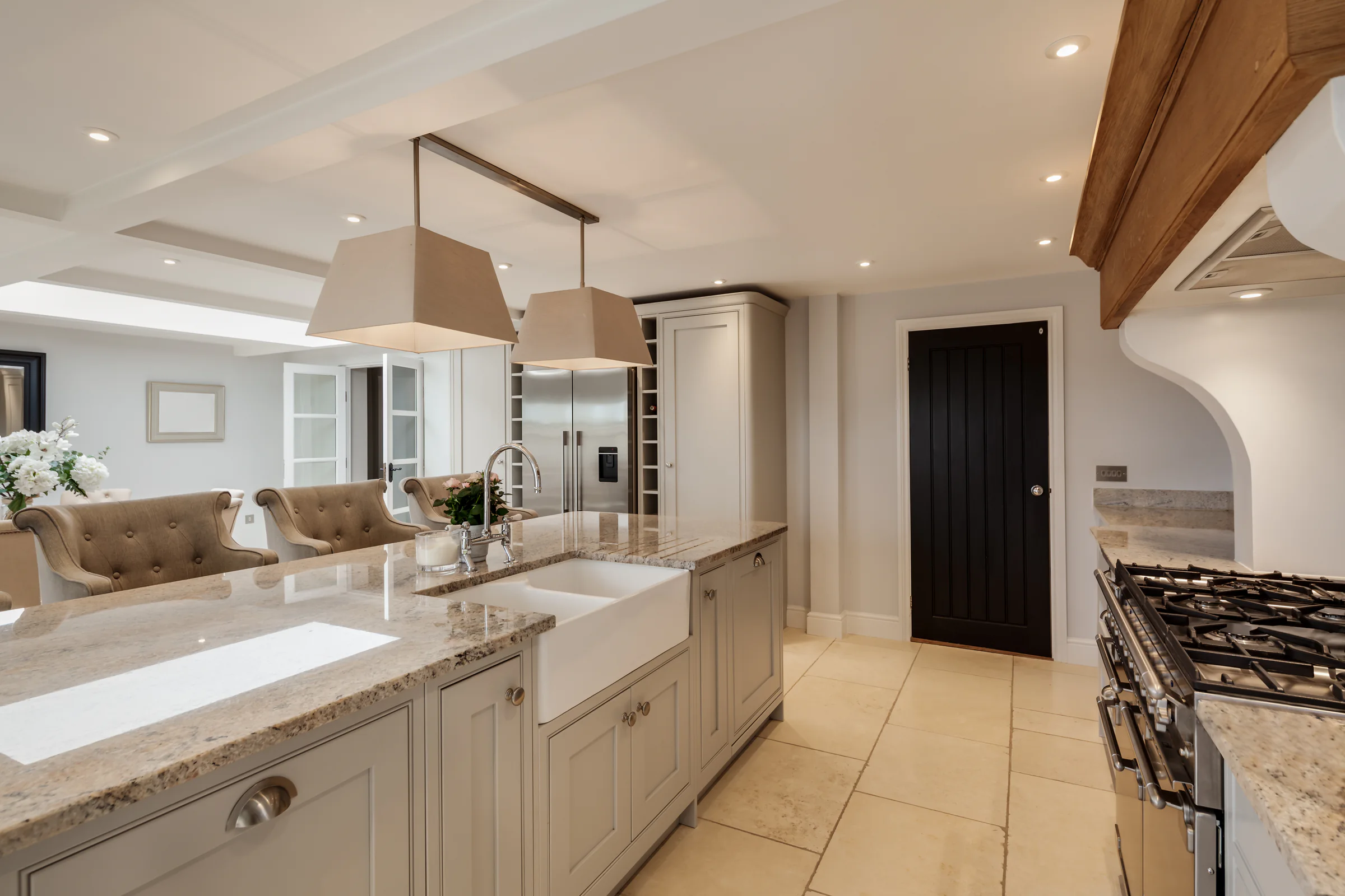 Traditional kitchen interior with painted cabinetry, timber worktops and daylight from a garden window