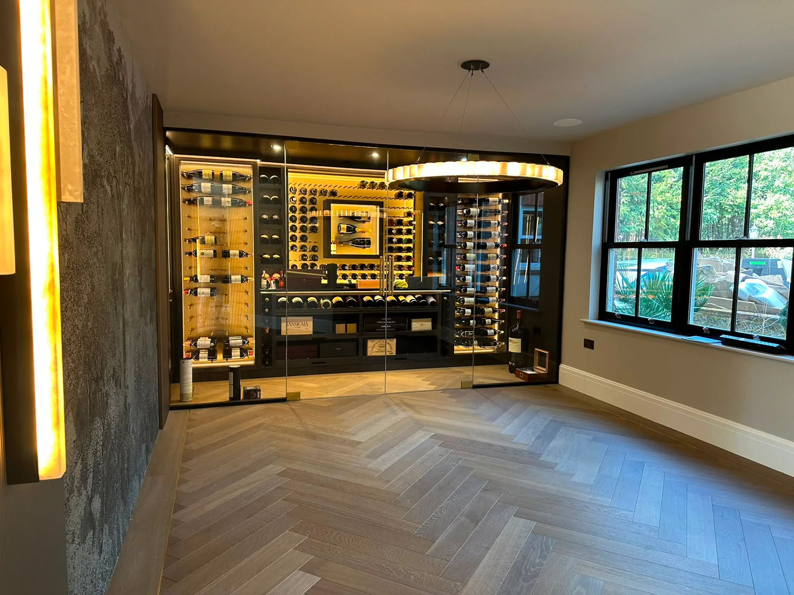 Completed JP Home Creations wine room with illuminated bottle storage and a glazed enclosure